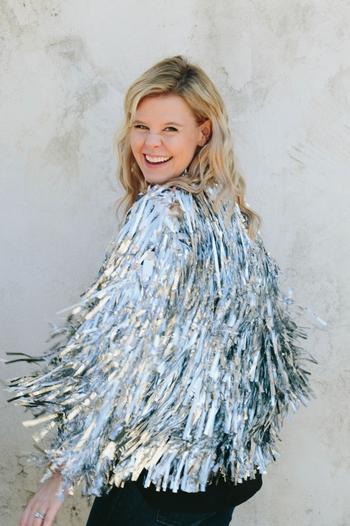 Christina laughing and twirling in her silver tinsel jacket