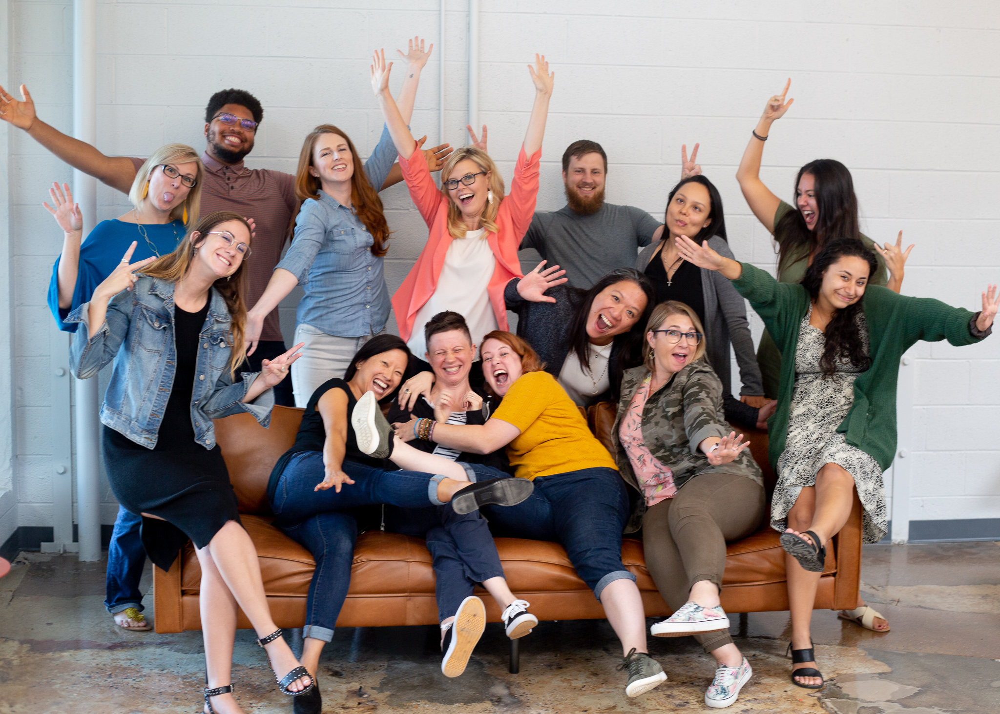 Group of women entrepreneurs being goofy and happy, along with a handful of male advisors that are allies