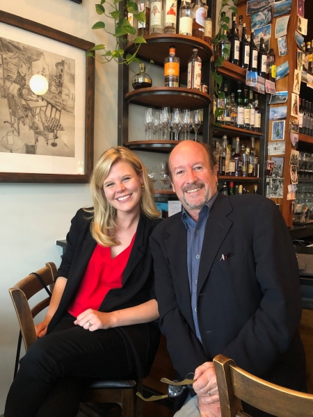 Christina sitting in front of a bar with her professor, David Sutherland